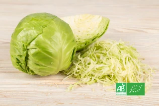 Chou lisse bio entier et émincé sur une table en bois, avec logo AB
