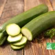 Courgettes bio entières et en rondelles sur une planche en bois, avec logo AB